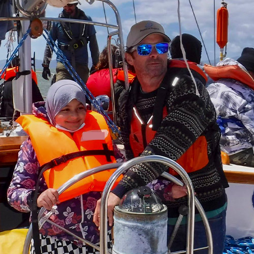 PegasusVoyagesNoChildLeftAshore Captain Bob Kingston with schoolchild helming the Pegasus